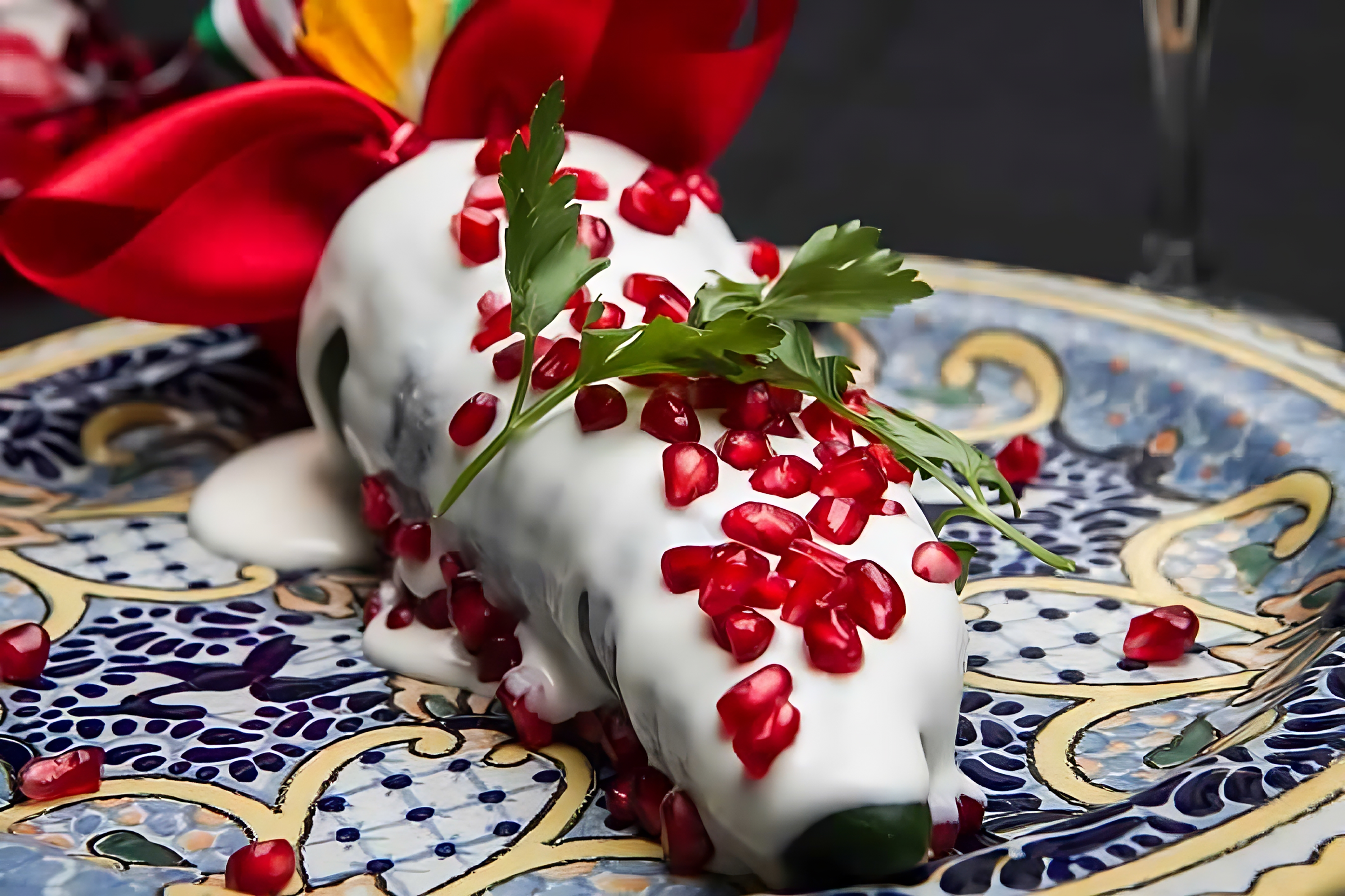 Stuffed poblano peppers with walnut sauce and pomegranate seeds.